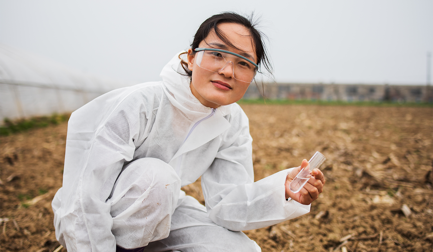 Scientist collects sample from field