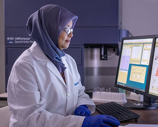 A scientist performing flow cytometry analysis.