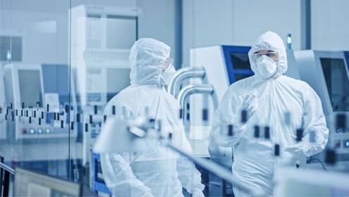 Two gowned up workers in cleanroom
